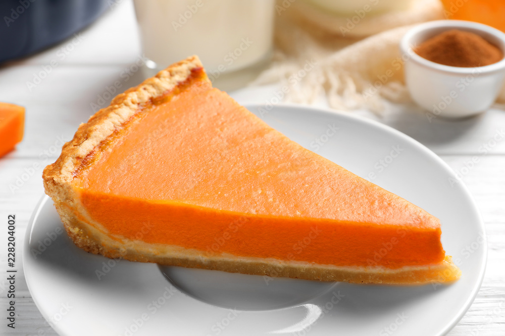 Plate with piece of fresh delicious homemade pumpkin pie on wooden table Plate with piece of fresh delicious homemade pumpkin pie on wooden table