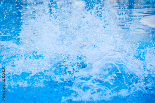 Blue swimming pool water splash. Freshness, fun, vacation, hotel, resort, summer holidays, diving, background texture concepts