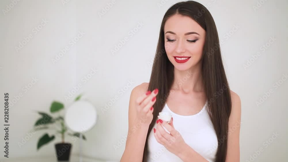 Concept Of Skincare. The Portrait Of Young Woman With Perfect Skin Applying a Day, Night Cream On Her Previously Cleansed Face Concept Of Skincare. The Portrait Of Young Woman With Perfect Skin Applying a Day, Night Cream On Her Previously Cleansed Face