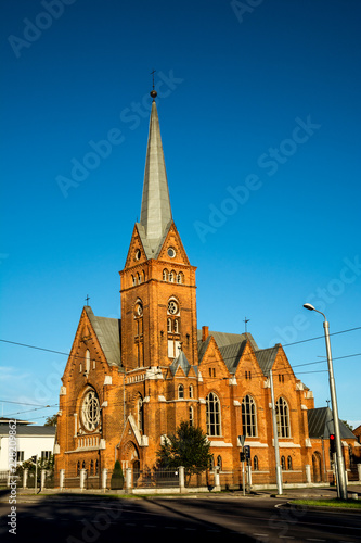 Exterior of Evangelical Lutheran Marthin Luther Cathedral in Daugavpils, Latvia on a clear blue sunny day at sunset. photo