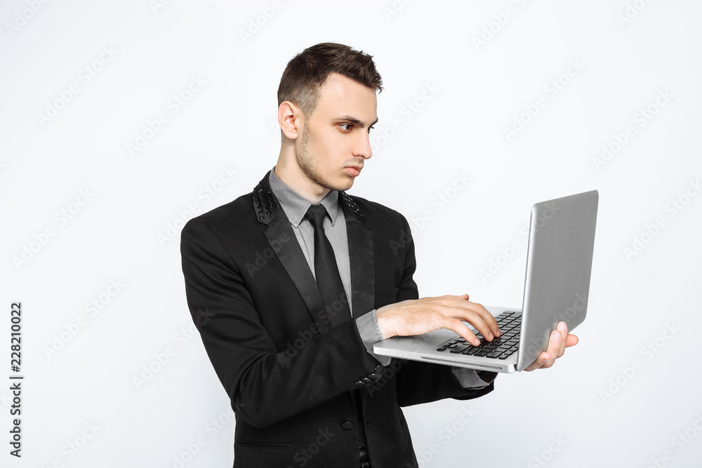 A successful man, in a black suit, looks thoughtfully into a laptop, a Bank employee, on a white background, black Friday, A successful man, in a black suit, looks thoughtfully into a laptop, a Bank employee, on a white background, black Friday,
