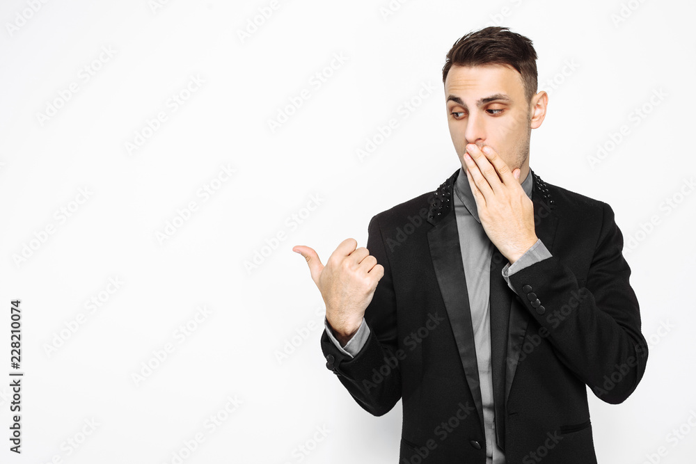 Shocked man in black suit, confident, pointing to empty copy space isolated on white background Shocked man in black suit, confident, pointing to empty copy space isolated on white background