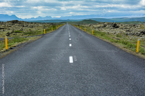 Empty asphalt road into wild nature of Iceland in summer