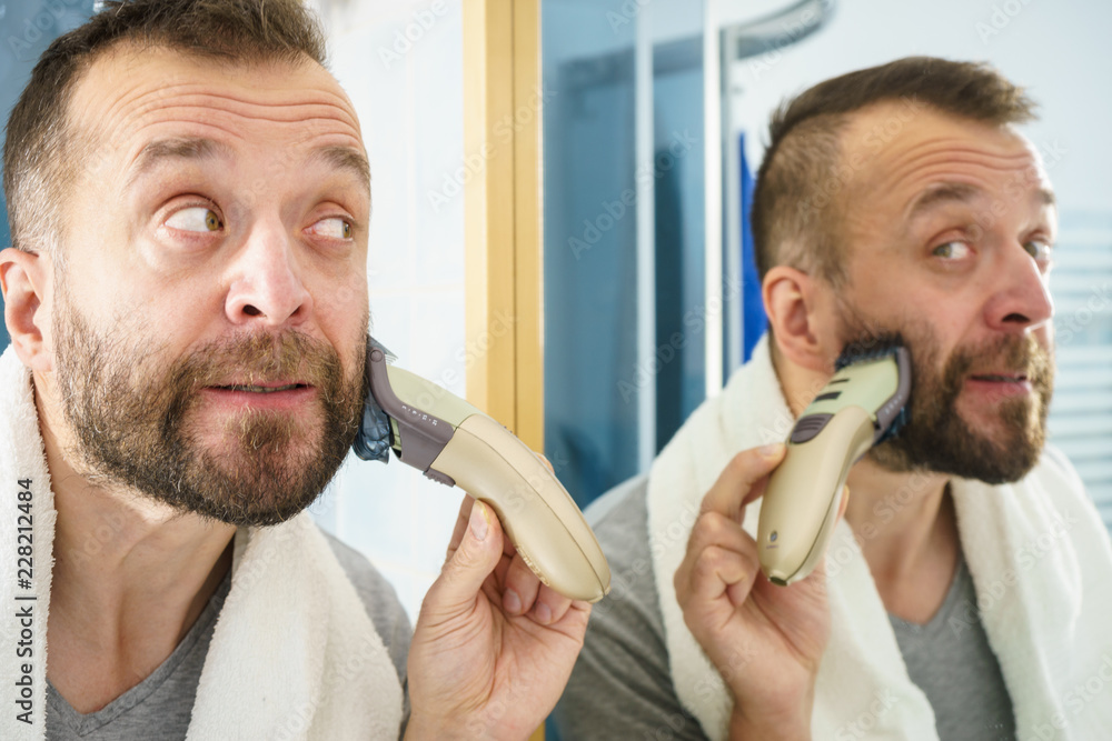Fototapeta premium Man shaving trimming his beard