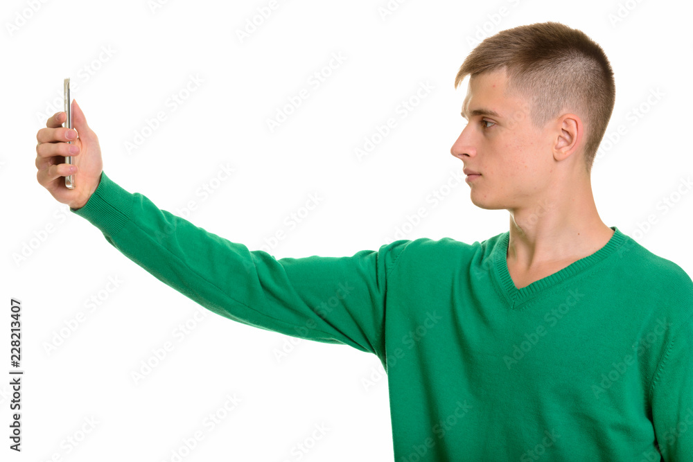 Profile view of young Caucasian man holding mobile phone Profile view of young Caucasian man holding mobile phone