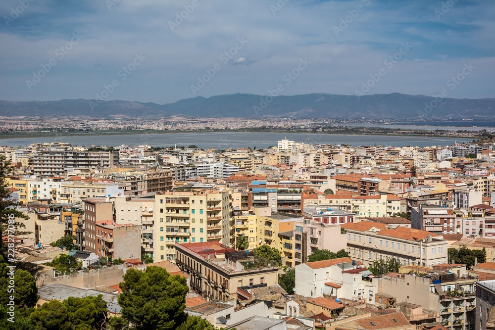 View on the city of Cagliari, the capital of Sardinia, Italy. Colorful houses and blue sky on a sunny day, mountains in the background.