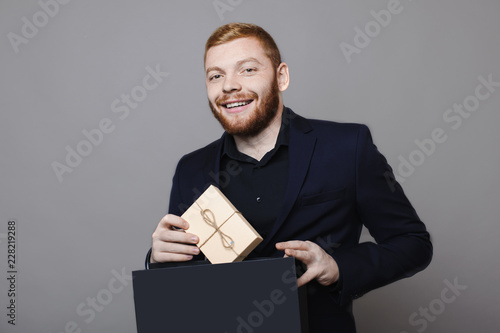 Cheerful man taking present from paper bag