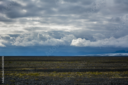Empty field in Skeidararsandur with cumulus dramatic clouds, Iceland in summer