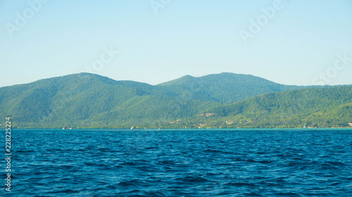 a big green island with deep blue dark sea in karimun jawa island