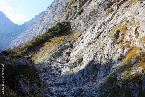 Mountain rocks with green cover in autumn in H  llental in German Alps