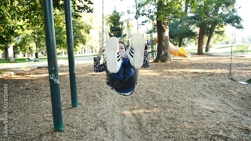 Girl with long brown hair swings and has victorious dismount in slow motion