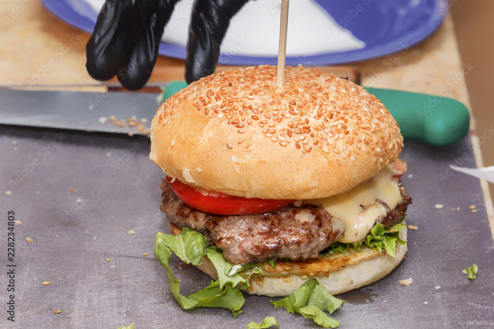 Ready hamburger is waiting for a buyer in a cafe on the street. Close-up Ready hamburger is waiting for a buyer in a cafe on the street. Close-up