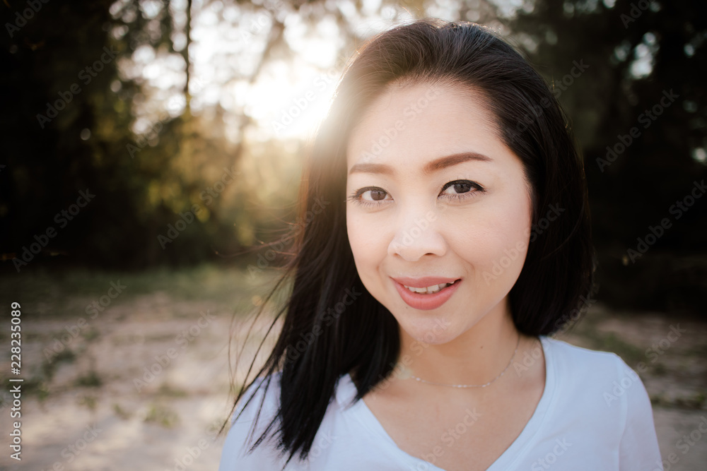 Beautiful woman walk outdoor along with sand and pine under warm sunlight.