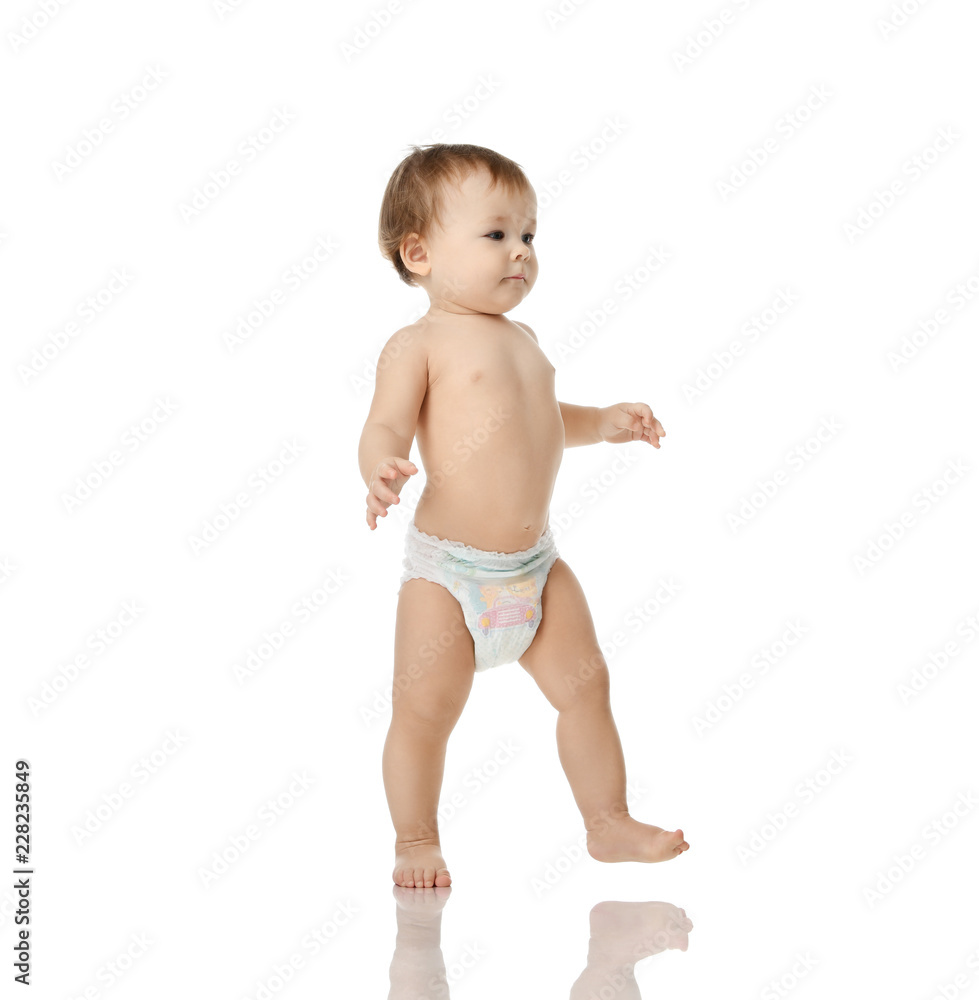 Infant child baby girl kid toddler in diaper make first steps Infant child baby girl kid toddler in diaper make first steps