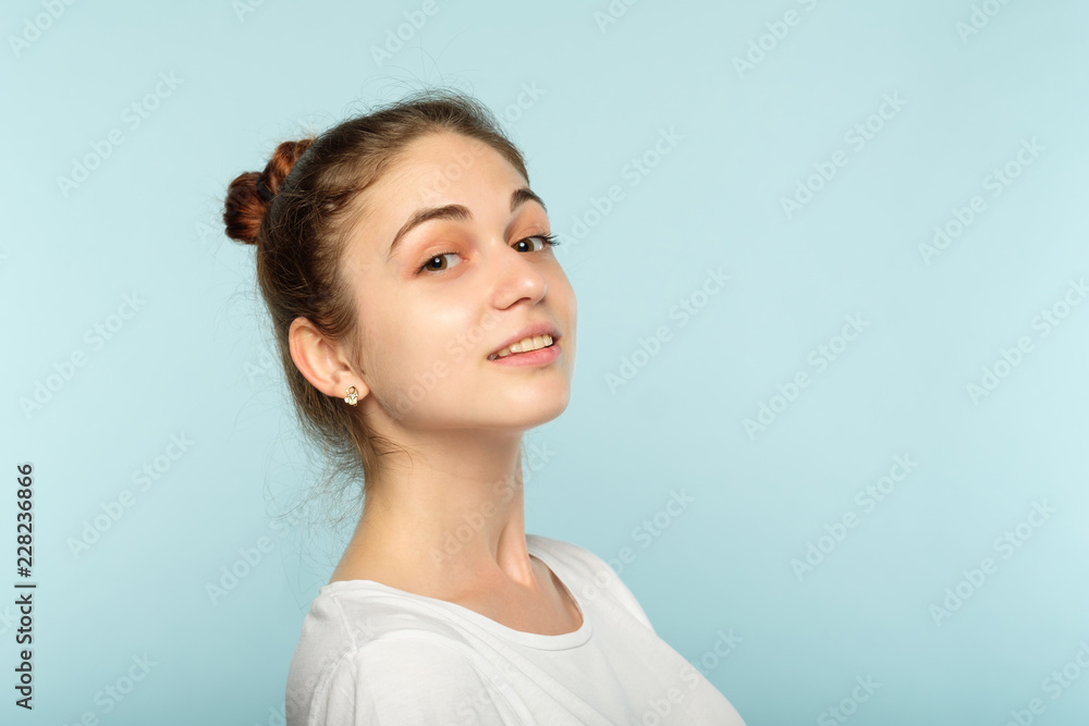 young beautiful woman with a light smile. cute teenage girl portrait on blue background. young beautiful woman with a light smile. cute teenage girl portrait on blue background.