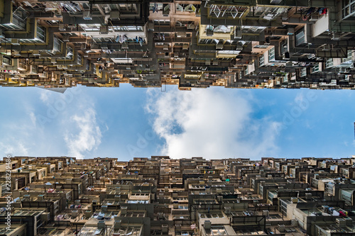 Tall skyscrapers towering above, looking toward the blue sky, crowded, dystopian cityscape, science fiction