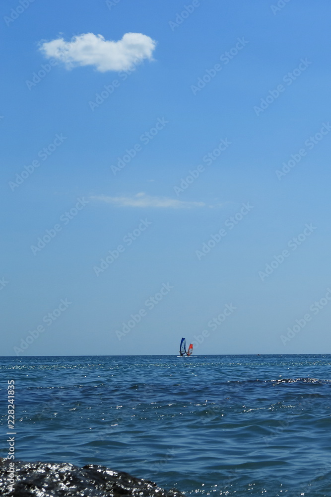 Walk on the sea on a board with a sail.