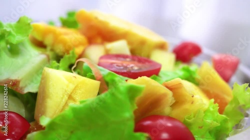 Organic green salad with various kinds of fruits in rotating macro shot - Healthy lifestyle photo