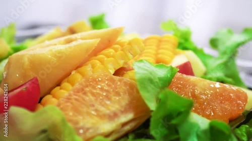 Organic green salad with various kinds of fruits in rotating macro shot - Healthy lifestyle photo