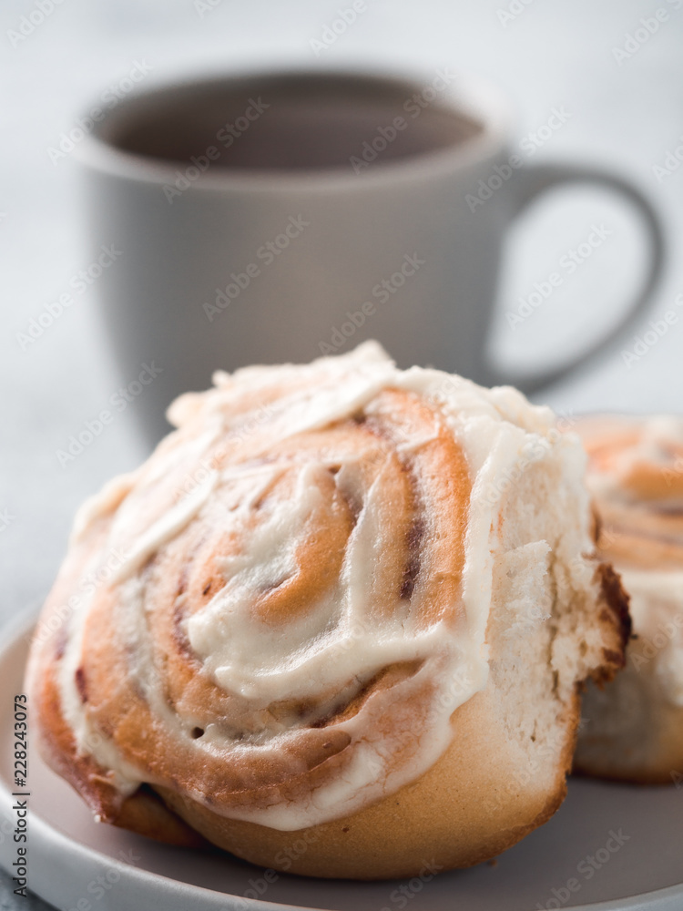 Vegan swedish cinnamon buns Kanelbullar with pumpkin spice,topping vegan cream cheese in plate with tea cup on table. Idea and recipe pastries - perfect cinnamon rolls.Copy space.Shallow DOF. Vertical Vegan swedish cinnamon buns Kanelbullar with pumpkin spice,topping vegan cream cheese in plate with tea cup on table. Idea and recipe pastries - perfect cinnamon rolls.Copy space.Shallow DOF. Vertical