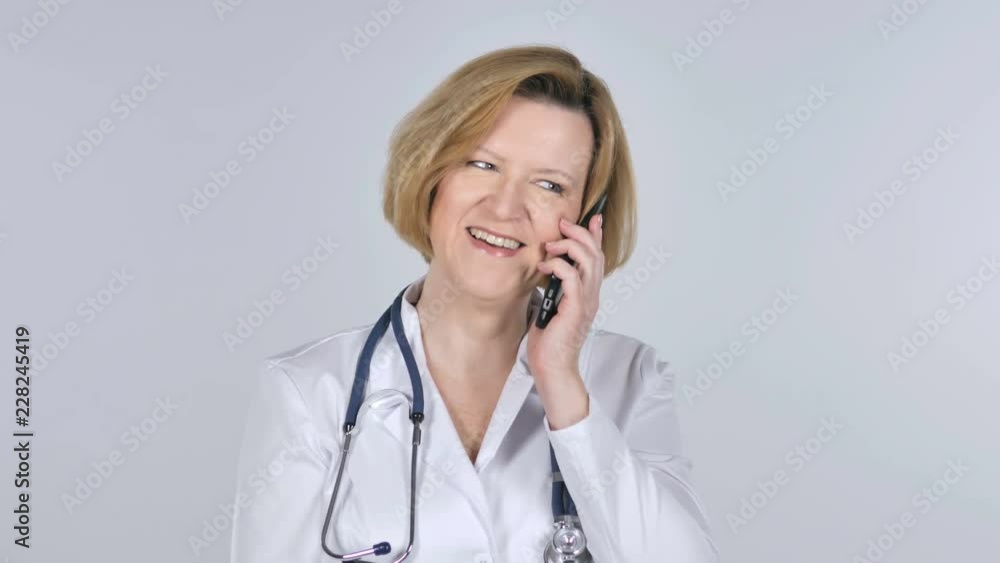 Old Doctor Talking on Smartphone, White Background Old Doctor Talking on Smartphone, White Background