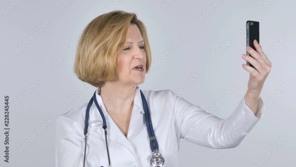 Video Chat with smartphone by Old Doctor, White Background Video Chat with smartphone by Old Doctor, White Background