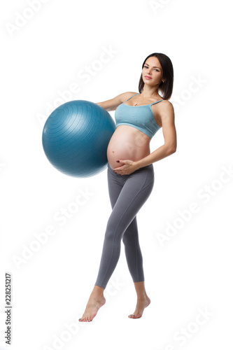 Slim pregnant woman is engaged in fitness with a ball isolated on a white background.