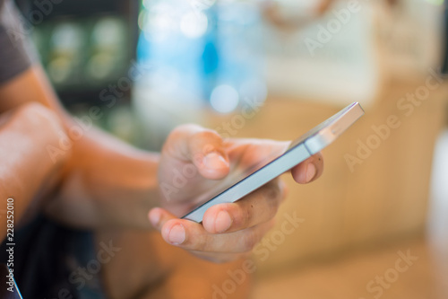 man holding smart phone for use internet with vintage tone. subject is blurred.