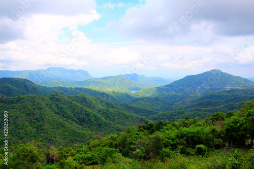 View of the lush green mountains and valley with floating clouds in the backdrop a scenic view from, Pha Sorn Kaew, in Khao Kor, Phetchabun, Thailand.