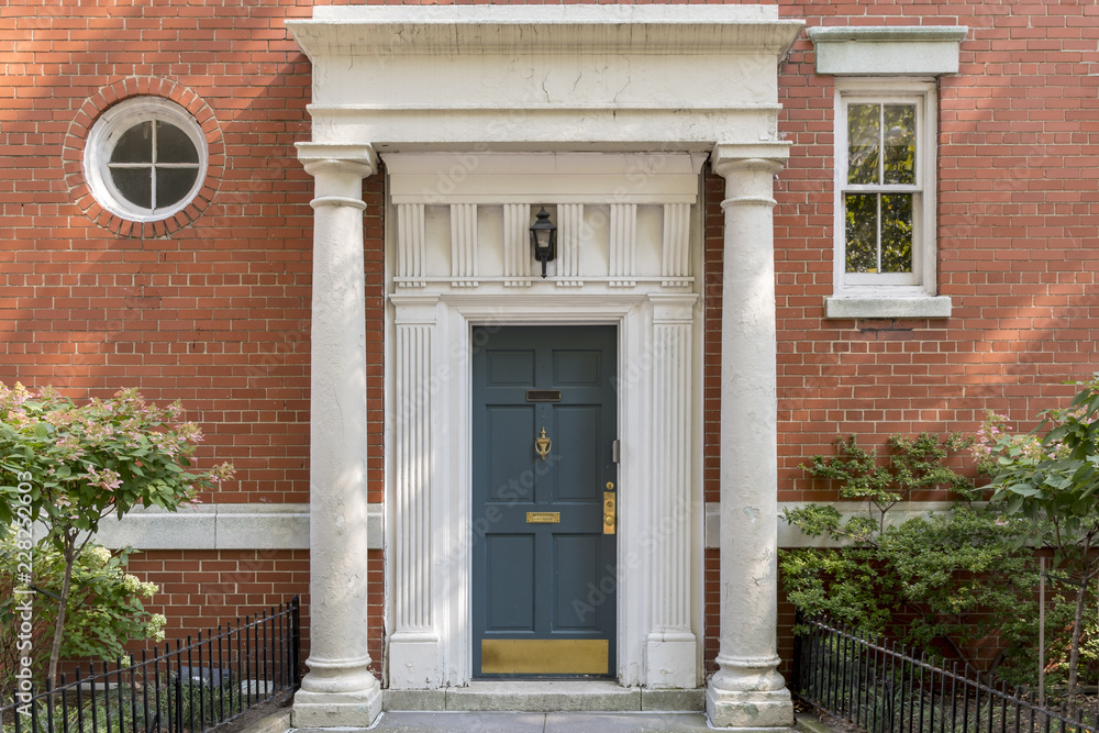 Decorated main door, columns and brick wall in New York Decorated main door, columns and brick wall in New York
