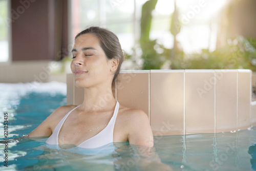 Attractive brunette woman relaxing in spa pool