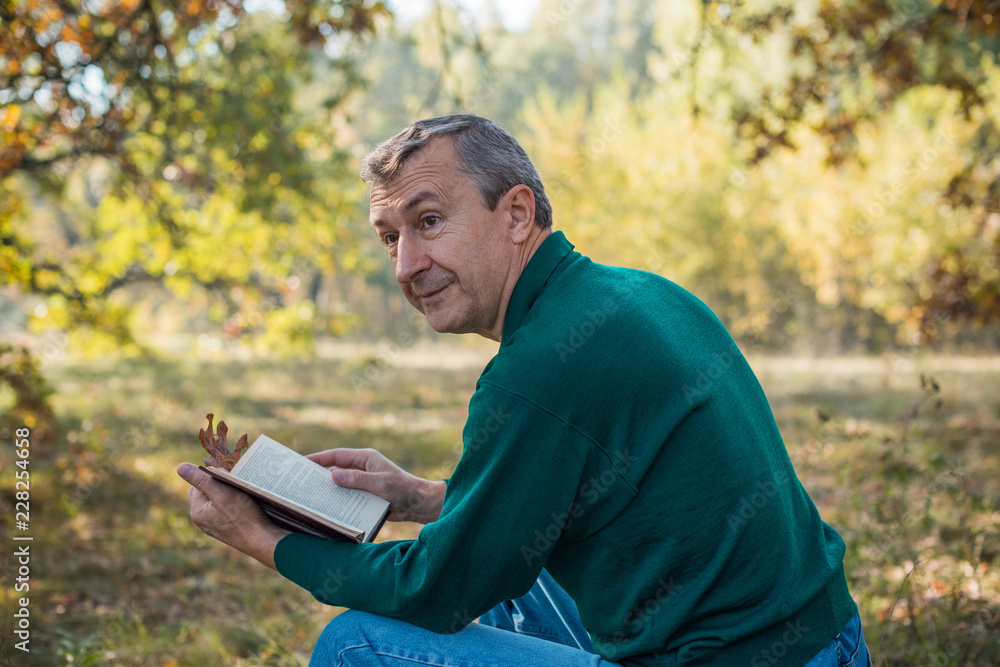 Older European senior man with a good mood in forest, outdoor portrait. The concept of life after 50 years Older European senior man with a good mood in forest, outdoor portrait. The concept of life after 50 years