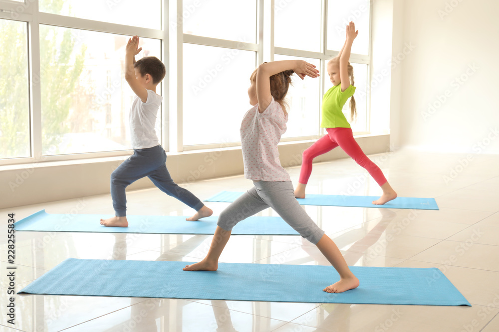 Naklejka premium Little children practicing yoga indoors