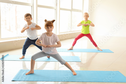 Little children practicing yoga indoors