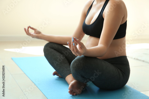Young pregnant woman practicing yoga at home