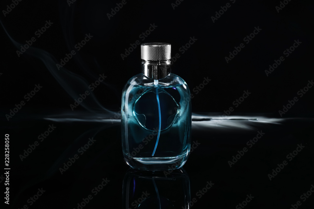 Bottle of perfume with fume on dark background Bottle of perfume with fume on dark background