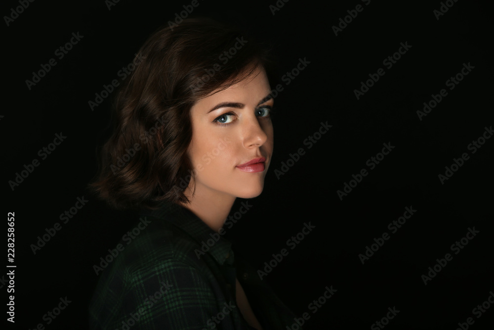 Portrait of beautiful young woman on dark background Portrait of beautiful young woman on dark background