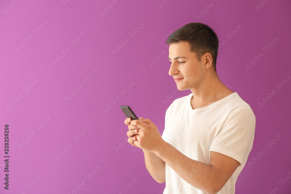 Young man with mobile phone on color background Young man with mobile phone on color background