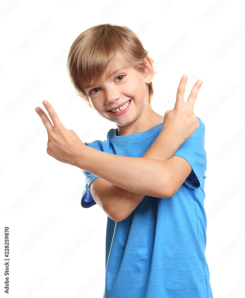 Little boy in t-shirt showing Victory gesture on white background Little boy in t-shirt showing Victory gesture on white background