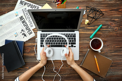 Woman using laptop with hea...