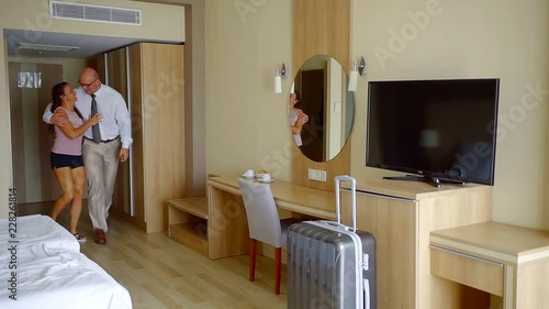 drunk man and woman are entering in hotel room, man is throwing his wife on a bed and falling on her