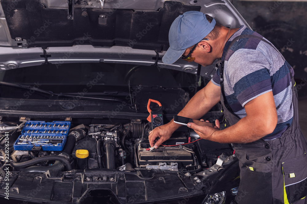 Car service worker diagnoses car breakdown. Car service worker diagnoses car breakdown.