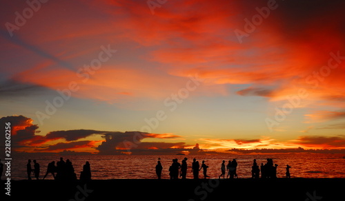 Silhouette of many people on the beach with seascapes on twilight sunset sky background