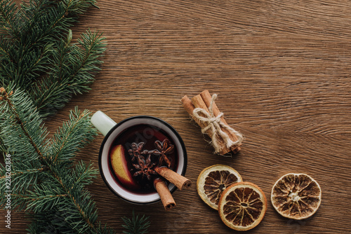 top view of mulled wine, dried oranges and fir twigs on wooden tabletop, christmas concept