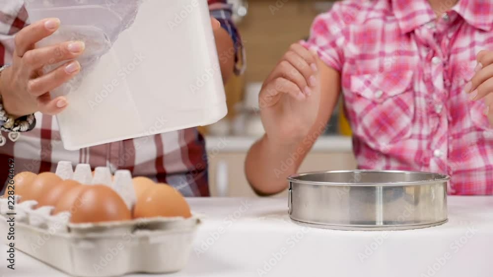At the kitchen daughter sifts flour through a sieve in slow motion. Dolly slider footage At the kitchen daughter sifts flour through a sieve in slow motion. Dolly slider footage