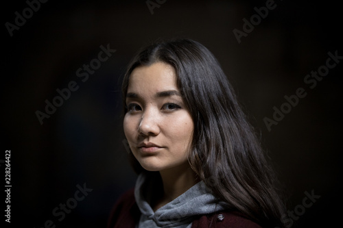 Portrait of young woman on a black background. Looking in the camera © KONSTANTIN SHISHKIN