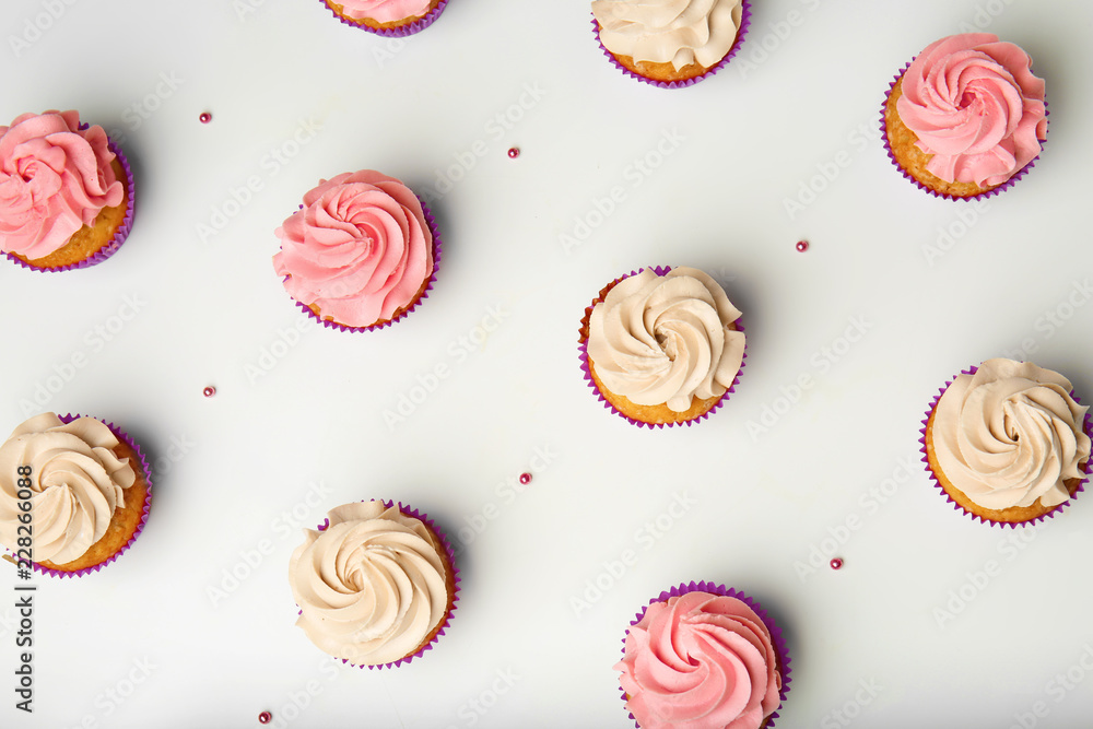 Delicious cupcakes on white background, flat lay Delicious cupcakes on white background, flat lay