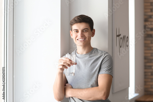 Young man with glass of wat...