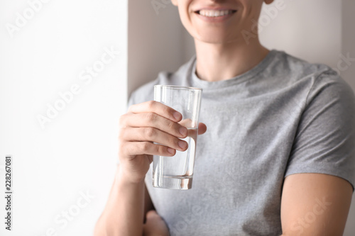 Young man with glass of wat...