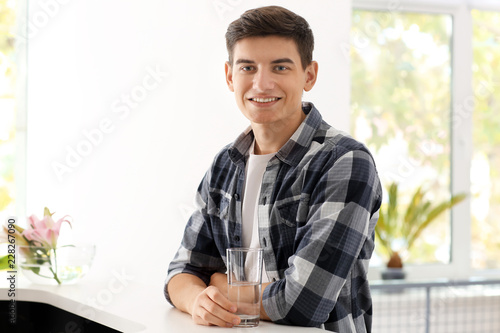 Young man with glass of wat...